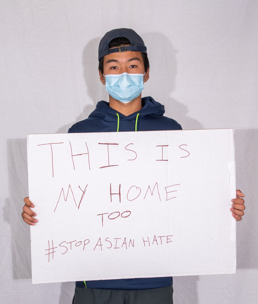 Nick Chenault holds a sign which said: "This is my home too #StopAsianHate."