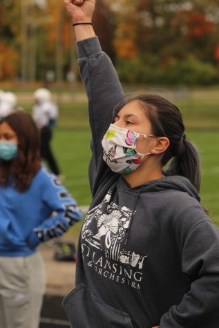 Grace Thompson chanting during cheer practice with a mask on.