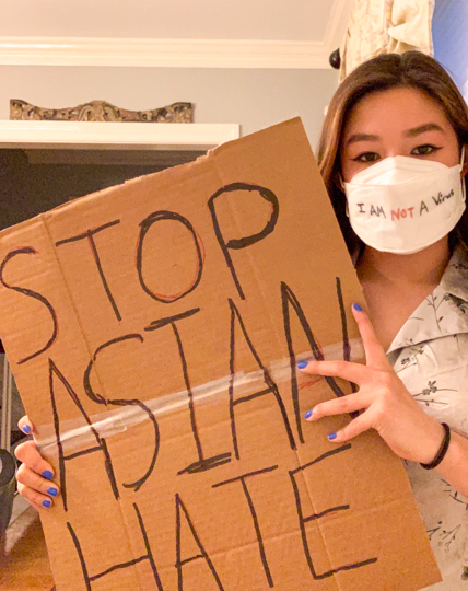 Xu-Li Valadez (11) holds a sign that said, "Stop Asian Hate," and wears a mask that said, "I am not a virus."