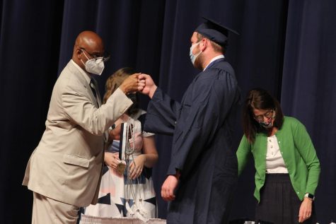 Walking across the stage Eathan Dewitt receives a fist bump from principal Andrew Wells at convocation on May 20 