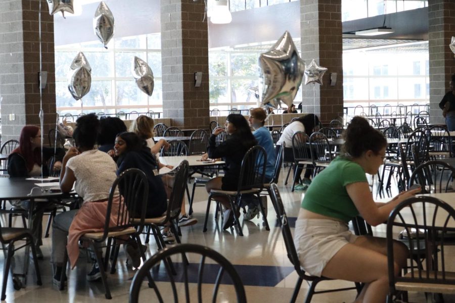 Awaiting new students to guide, volunteers from NHS gather in the lunchroom.