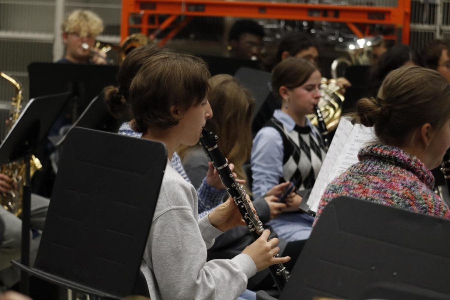 Warming up with the rest of Wind Ensemble on Oct 27, Erika Stokstad (11) plays a scale on her clarinet.