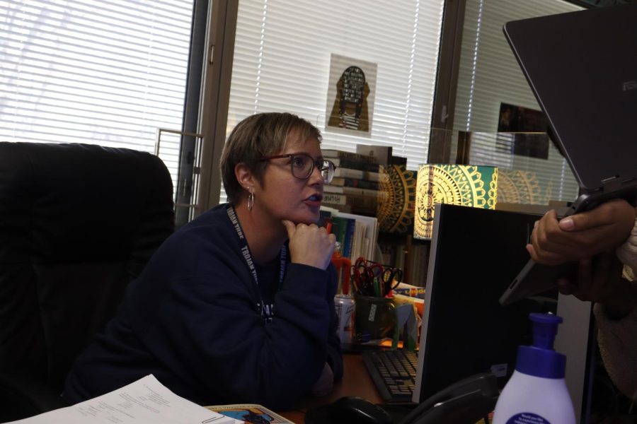 Sitting at her desk on Oct. 28, English teacher Emily Holmes helps one of her AP literature students in 5th hour.