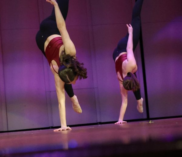 Anna Rensing (12) performs alongside Anna Dean (11) in the multicultural assembly Feb. 2 as part of the dance team routine in the auditorium.