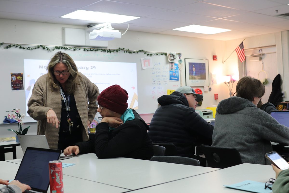 English teacher Sheri Sekya talks with a student about their work in exploring education class on Jan 28.