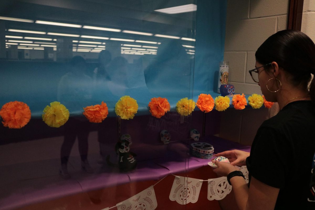 Marisa Serrato-Gamez(11) places her sugar skull in LSU's display case.