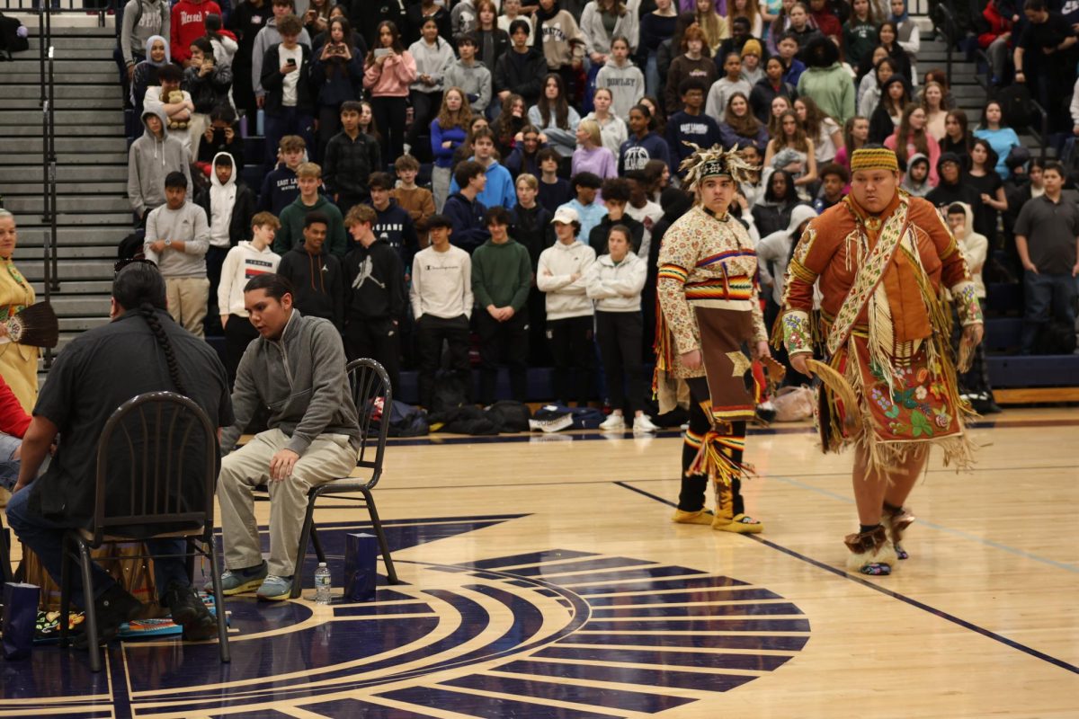 After students rose out of respect for the Anishinaabemowin tradition, the dancers began to move their way in a circle around the centered drummers and singers at the assembly on March 21.