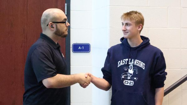 Kai Martin (12)  introduces himself to security guard Frank DeCardens in the high schools front hallway, while they talk about the safety of the new bond proposal on April 12.