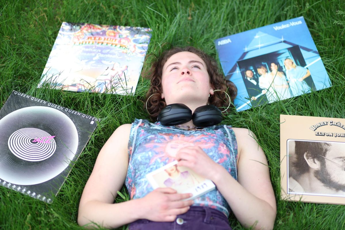 Belle Potter (10) lays in the grass surrounded by various vinyls from her collection on May 14. 