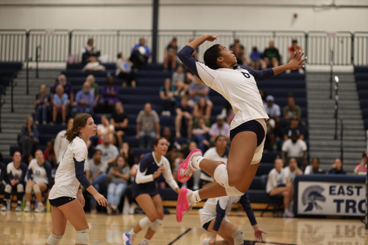 Ariyanna Johnson (11) prepares to serve a ball in East Lansing's game against Dewitt on Sep. 19. 