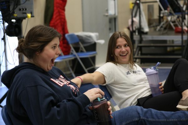 Teachers Katie Smith and Madi Zink csit on deck coaching boys swim season together on Feb. 8 2024