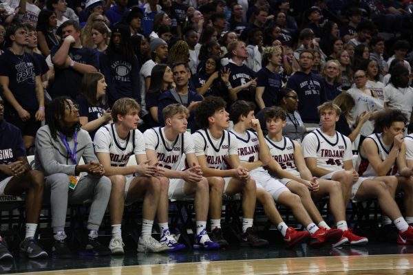 Sitting on the sidelines (pictured left to right) David Foster (12), Henry Peck (11), Isaiah Lott (12), Ben Fletcher (12), Owen Fortman (12), Paul VanDam (11), and Brady Johns (11) watch as their team plays in the MHSAA basketball state finals. 
