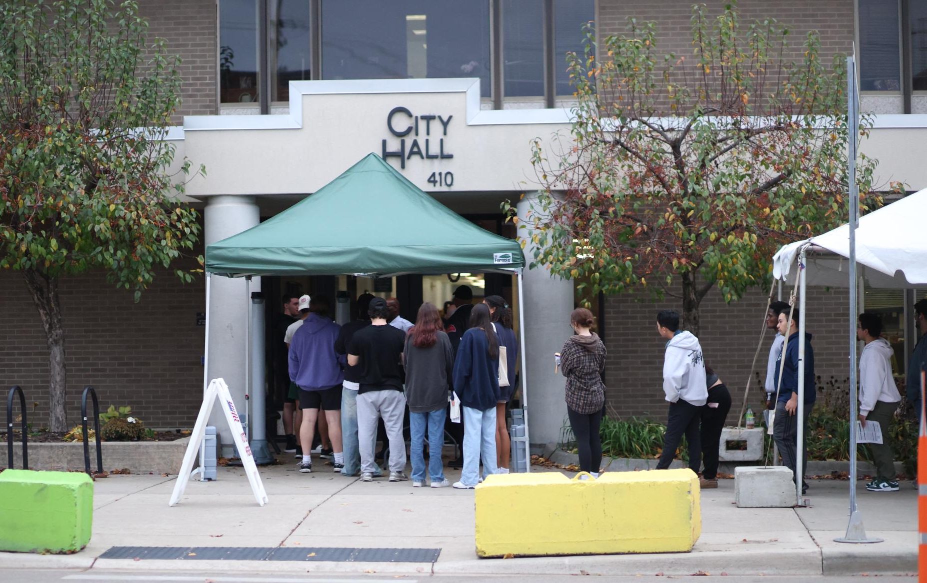 Outside of East Lansing's City Hall, voters wait to cast their ballots on Nov. 5, 2024. As of 5 pm, the line stretched around the block across from Dublin Square.