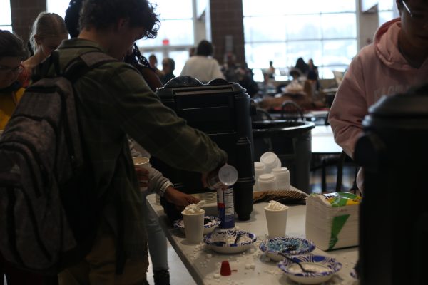 Standing in the line for cocoa, Sullivan Phillip (10) adds whipped cream to his cup.