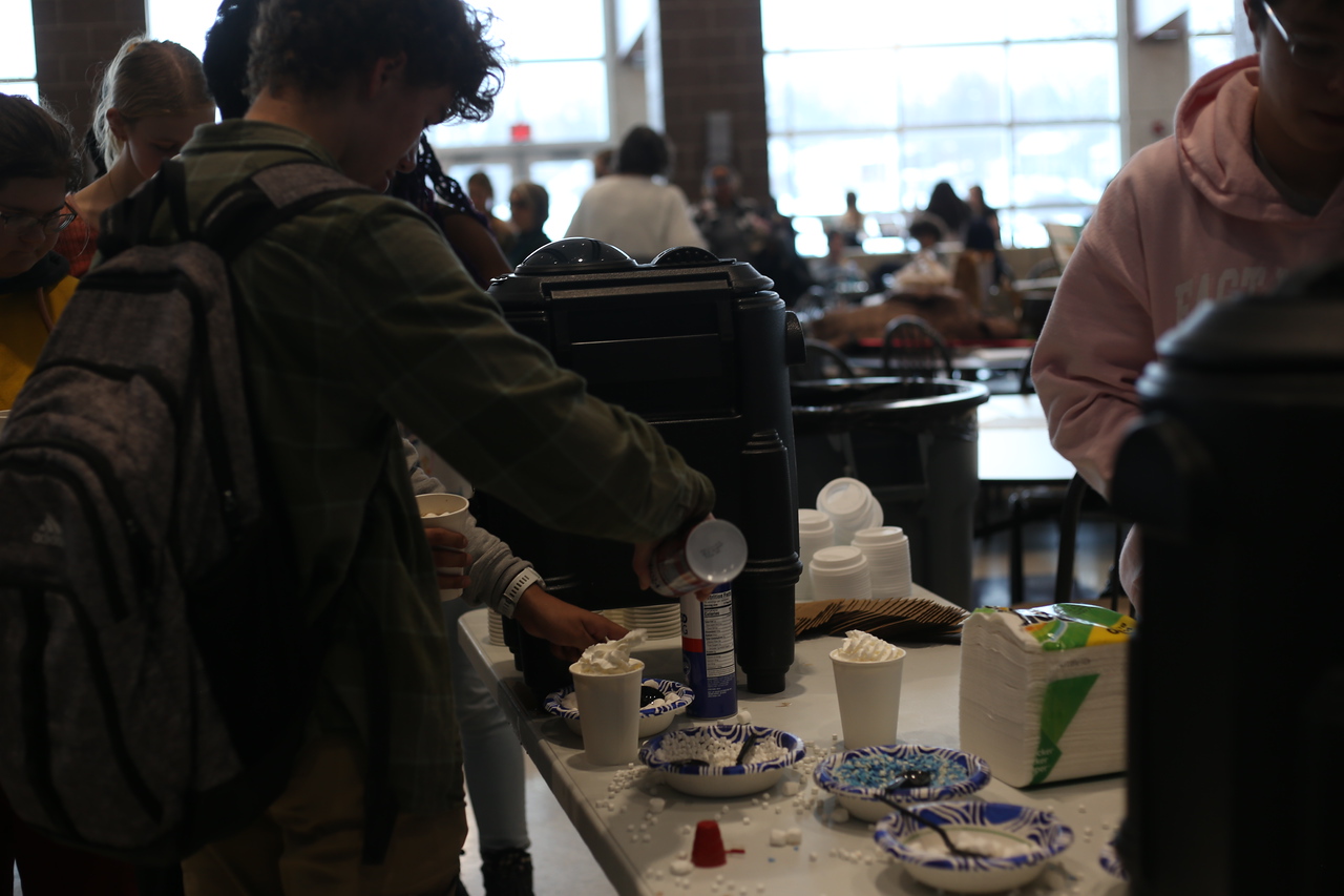 Standing in the line for cocoa, Sullivan Phillip (10) adds whipped cream to his cup.