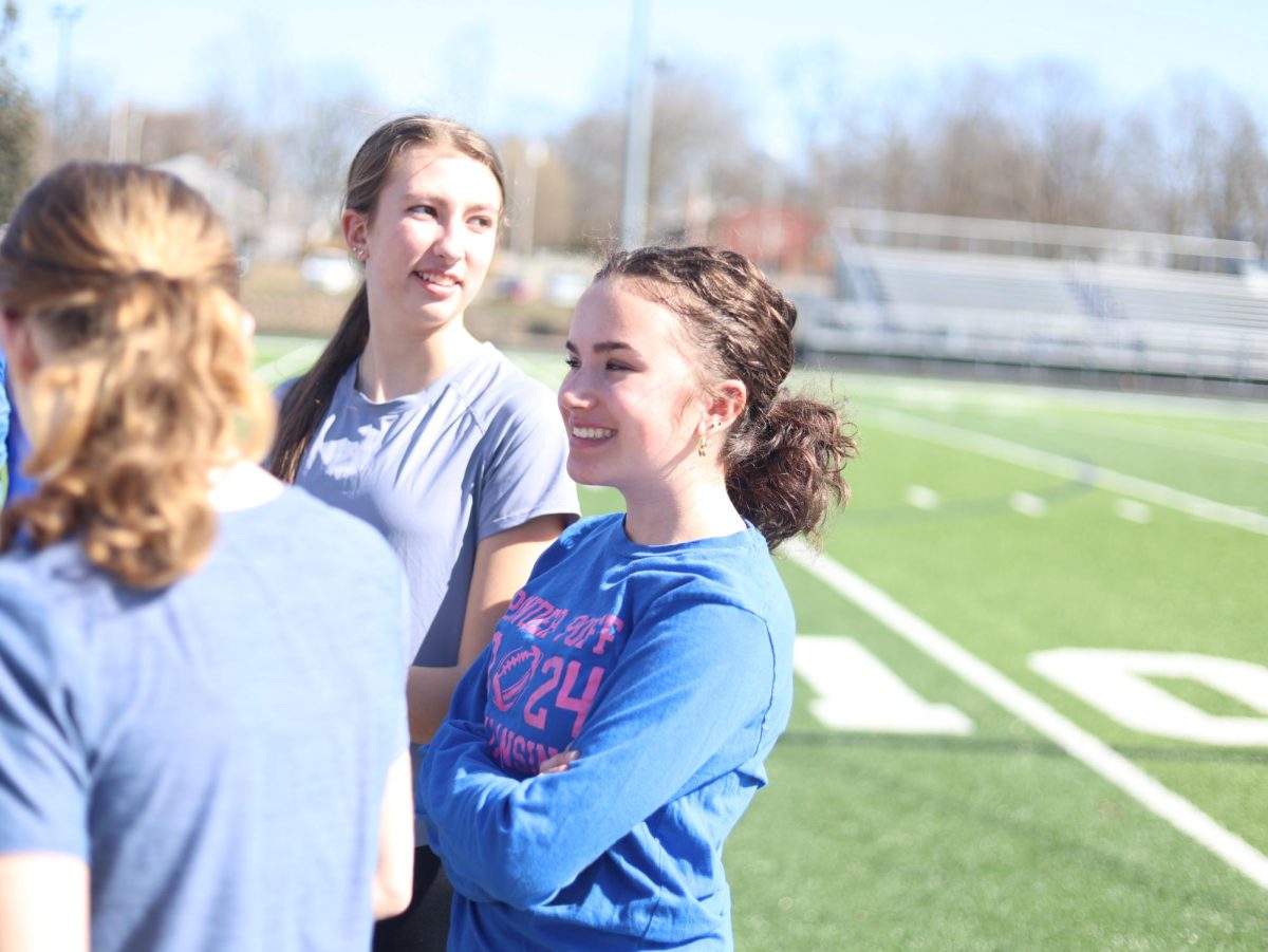 Madeleine Plowright (11) stands with the girls long distance track team during track practice on March 10. This was the first official day of track practice.