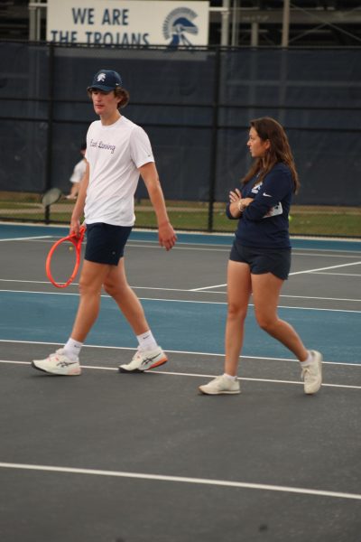 Walking while talking, coach Alexandra Cross gives strategies and advice to Miles Johnston (12). Cross is the wife of the official varsity boys' coach, Cody Cross, as well as a devoted tennis player. 