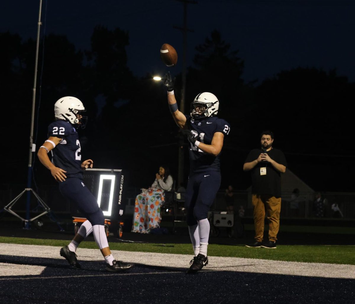 Cameron White (10) and Baylor Schanski (11) celebrate after Schanski scored a touchdown during the homecoming game against Okemos Friday, Sep. 21.
