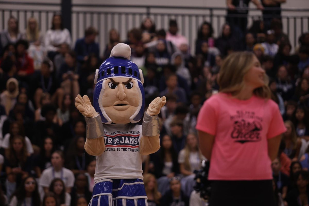 Troy Trojan (left) cheers during the senior varsity cheerleader dance portion of the homecoming pep assembly on Friday, Sep. 19. 