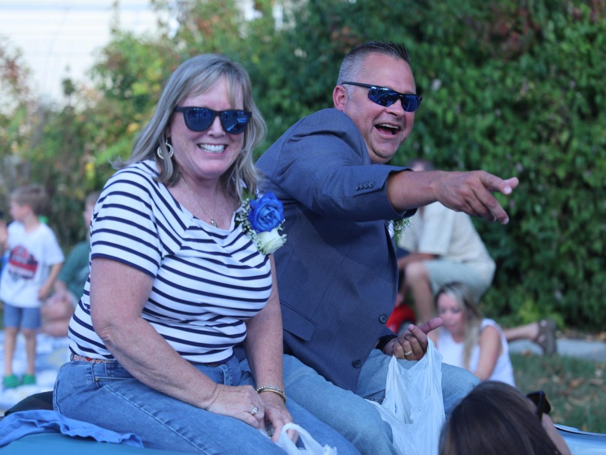 Terri Craig and Robert Smith, the 2025 Grand Marshals of the parade, lob candy to the eager crowd on Sep. 19. Both Craig and Smith are retired ELHS teachers.