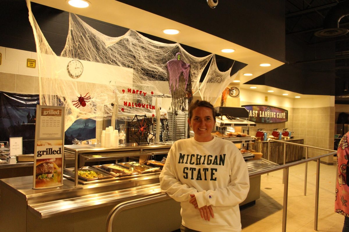 The Director of Dining Services, Megan Haase, stands in the lunchroom, in front of a Halloween display on Oct. 29. Her favorite part of her job is menu planning.