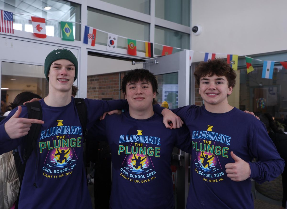 Ian Spencer (10), Daniel Newcombe (10) and Max Anderson (10) pose inside the foyer of Red Cedar Elementary School on Feb. 11. After they participated in the polar plunge earlier that morning, they waited for the bus to bring them back to the high school.