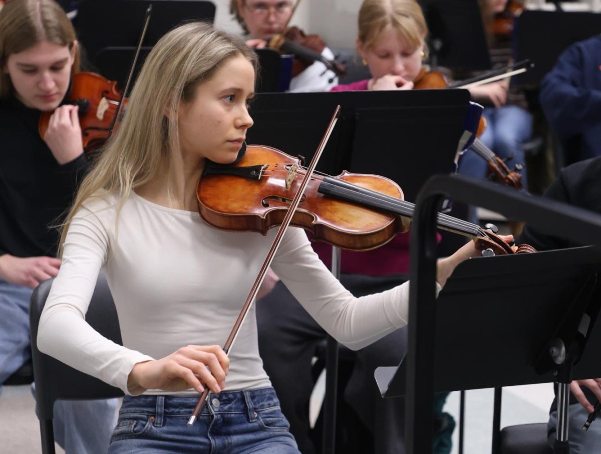 Playing her violin, Sima Bezuglova (12) sits during Symphonic Orchestra class on Feb. 4. Bezuglova played the violin for most of her life and planned to pursue a career as a professional violinist.  