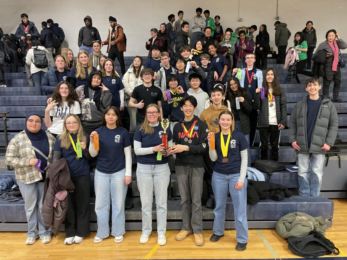 Celebrating their sixth place finish at the Haslett Invitational on Jan. 24, the Science Olympiad team poses with their trophy. The team had over 30 members competing in 23 different events.