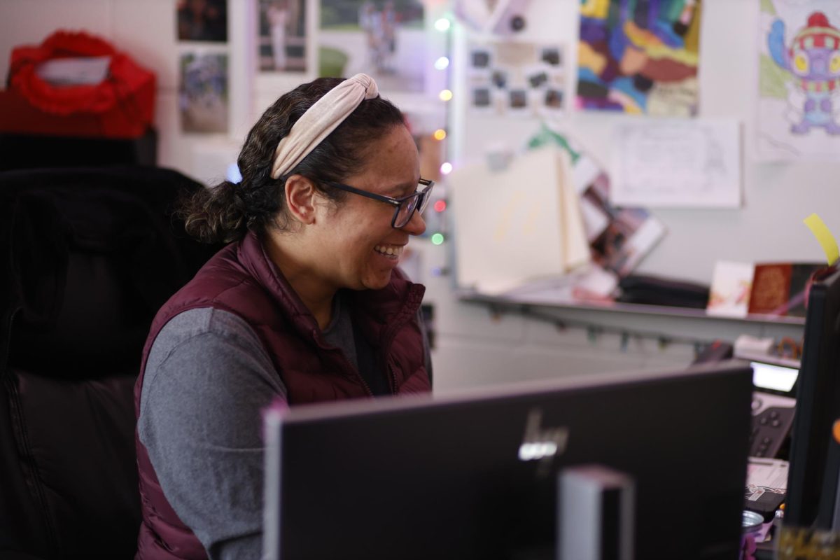 Smiling at her desk after school on Feb. 24, English teacher Stirling Korte works on her computer. Korte has worked hard to make her classroom decor friendly and welcoming.