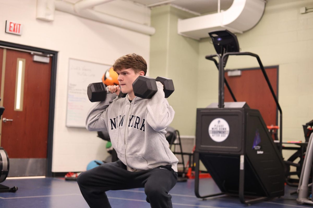Squatting, Henry Foster (11) works out in the ELHS weight room. He has been going to the gym regularly for about a year and a half.

