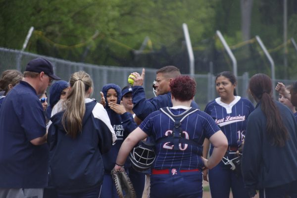 Addressing his team, new varsity softball Corey Cataline wraps up the April 27 game. Cataline joined the team this year, inspired by past coaching and family softball experience.