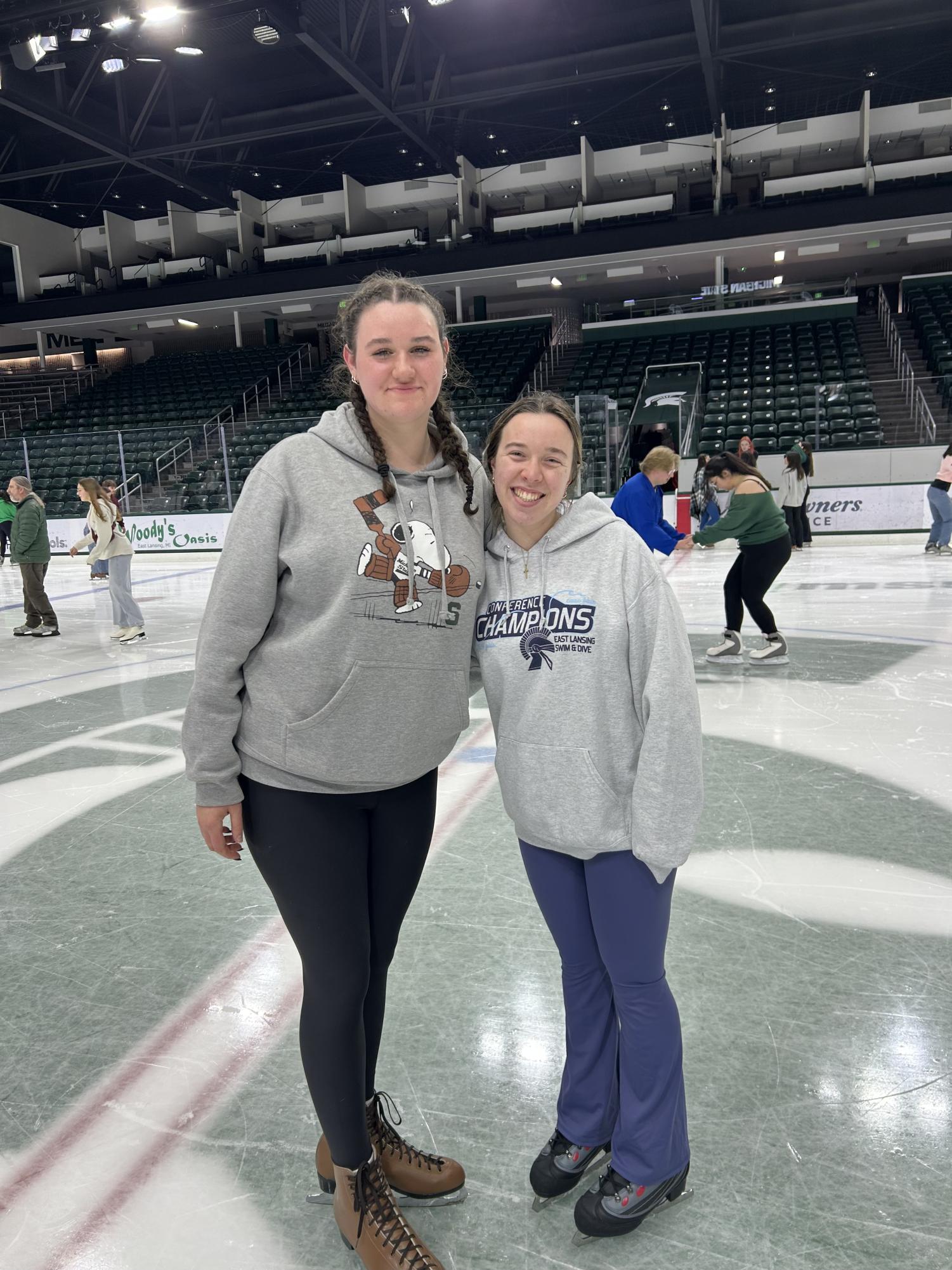 Taking a relaxing stroll around Munn Ice Arena, Abby Schuette (10) (Left), and Belly Gast (12) (Right) stop skating and hug for a picture.