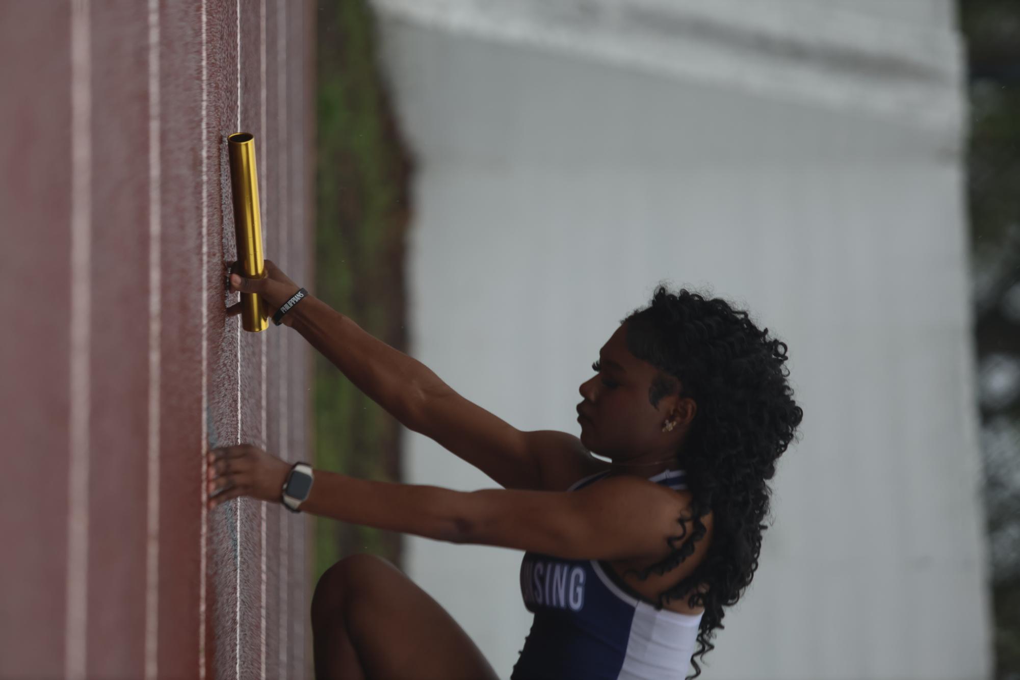 Preparing for her relay, Ayreon Little (11) leads off during the 400x2 relay. Little has been running for over a decade.